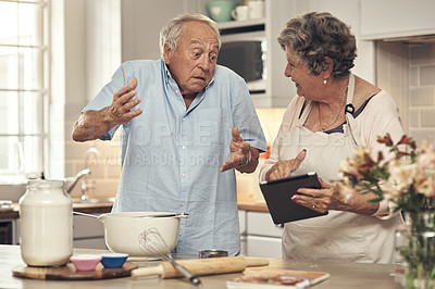 Buy stock photo Shot of a senior man shrugging while cooking with his wife at home