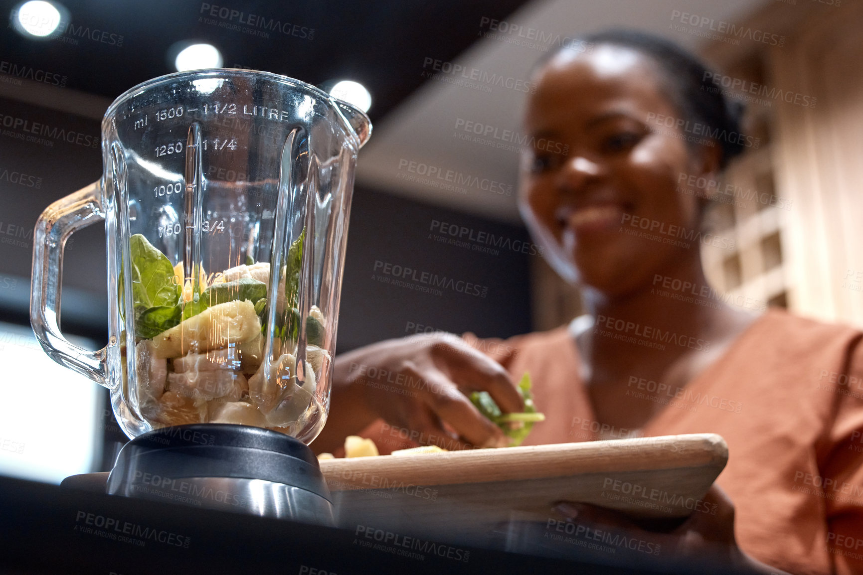 Buy stock photo Shot of a young woman making a healthy smoothie at home