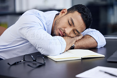 Buy stock photo Shot of an exhausted businessman having a quick nap on the desk at work