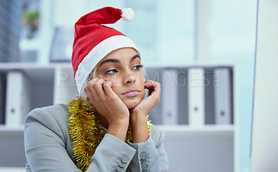 Buy stock photo Shot of a sad young woman lost in thought at her desk in the office