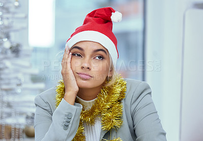 Buy stock photo Shot of a sad young woman lost in thought at her desk in the office