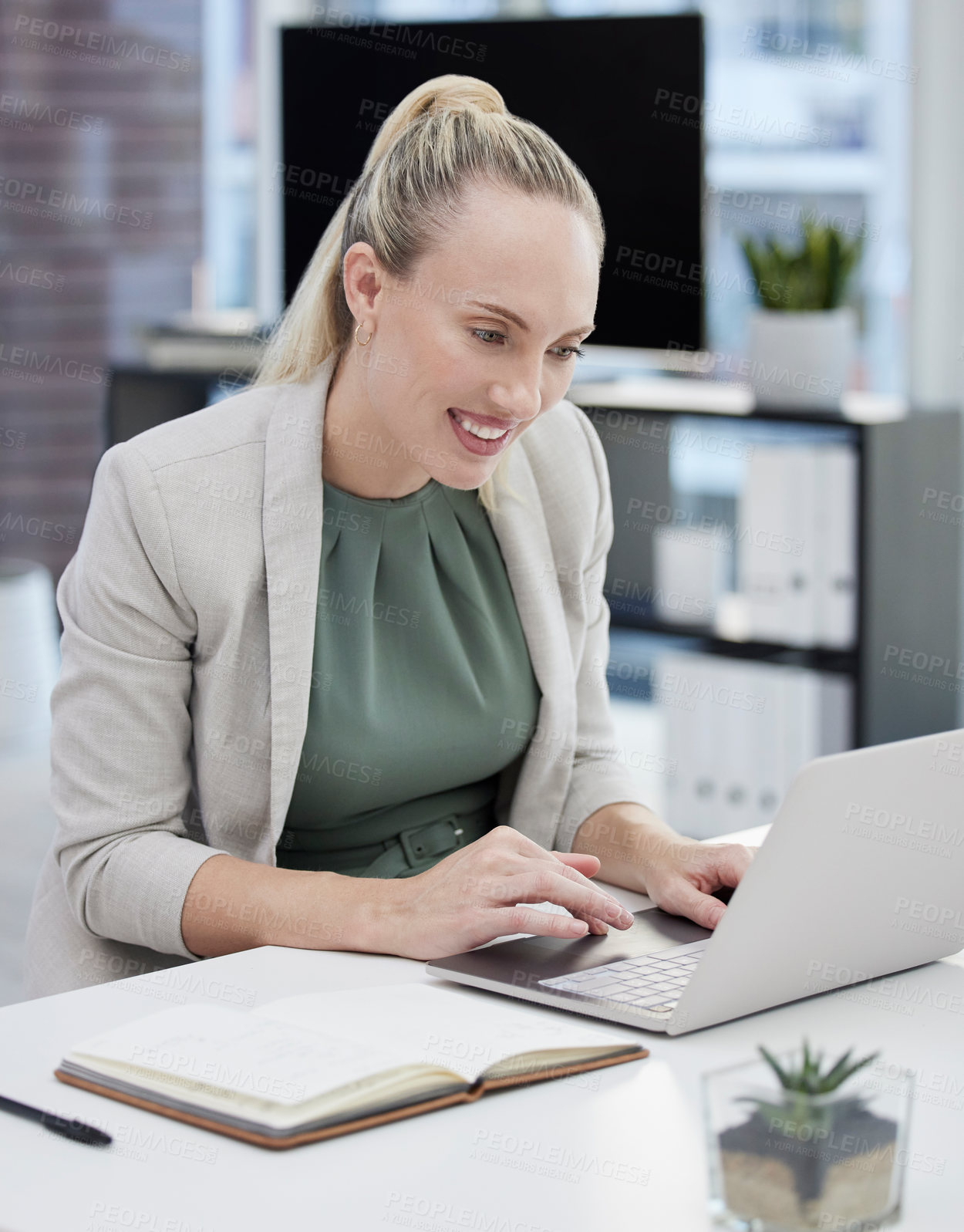 Buy stock photo Shot of a young businesswoman working at her desk using her laptop