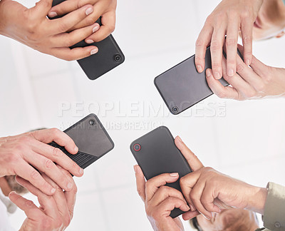 Buy stock photo Shot of a group of coworkers together using their smartphones