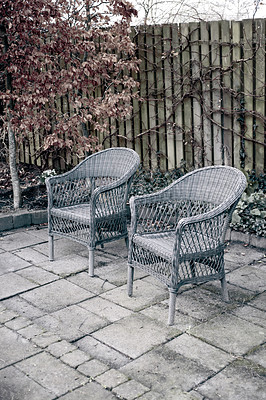 Buy stock photo Woven armchairs outside in a rustic garden with autumn plants for relaxing after gardening. Yard landscape with two wooden chairs in nature in a backyard patio to enjoy peace and quite of winter