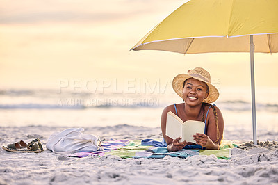 Buy stock photo Portrait of a beautiful young woman relaxing with a book at the beach