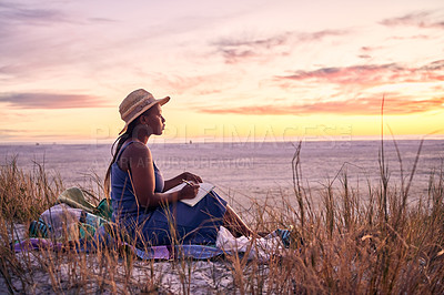 Buy stock photo Black woman, relax and book on beach in sunset with diary or journal for vacation in nature outdoors. African female person relaxing on ocean coast with notebook in morning sunrise and holiday travel