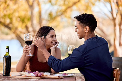 Buy stock photo Shot of a young couple having wine on a date on a wine farm