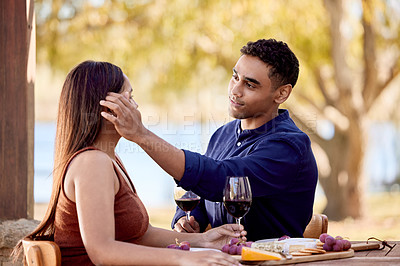 Buy stock photo Shot of a young couple having wine on a date on a wine farm