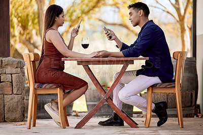 Buy stock photo Shot of a young couple having wine on a date on a wine farm