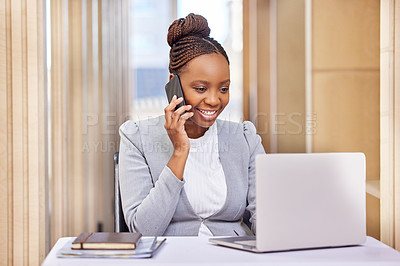 Buy stock photo Cropped shot of an attractive young businesswoman making a phonecall while working on her laptop in the office