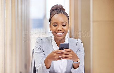 Buy stock photo Cropped shot of an attractive young businesswoman sending a text message while working in her office