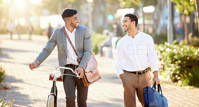 Buy stock photo Shot of two young businessmen walking through the city together during their afternoon commute from the office