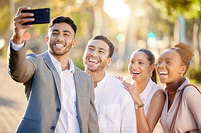 Buy stock photo Shot of a diverse group of businesspeople standing together in the city and using a cellphone to take a selfie