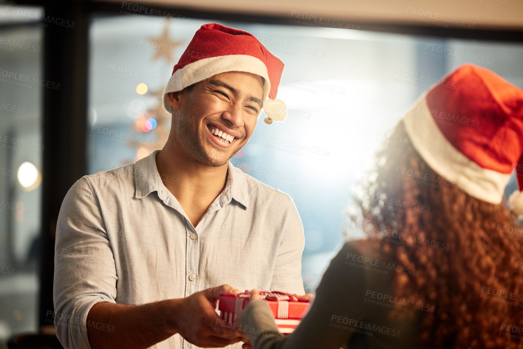 Buy stock photo Shot of two young businesspeople celebrating Christmas at work