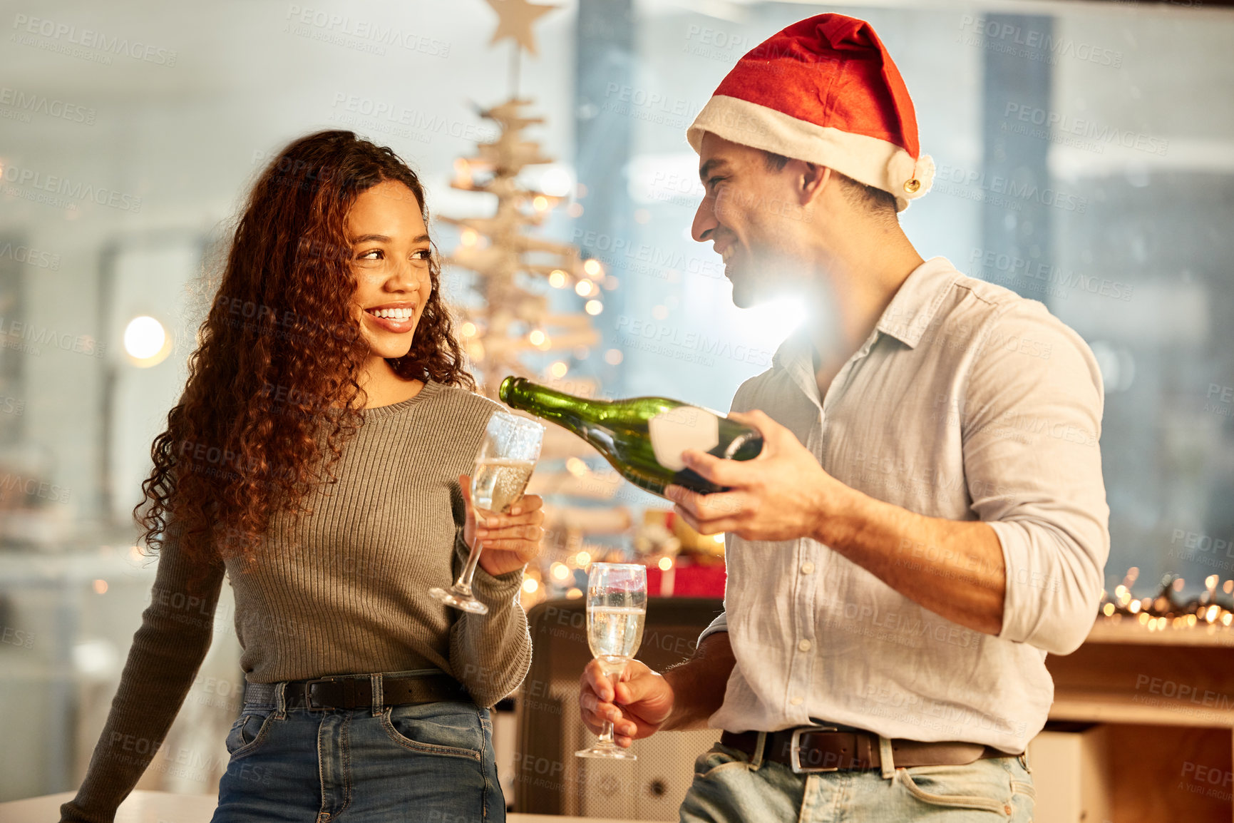 Buy stock photo Shot of two young businesspeople celebrating Christmas at work