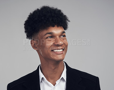 Buy stock photo Studio shot of a young businessman looking away thoughtfully against a grey background