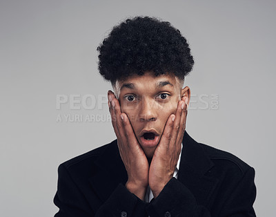 Buy stock photo Studio portrait of a confident young businessman looking shocked against a grey background