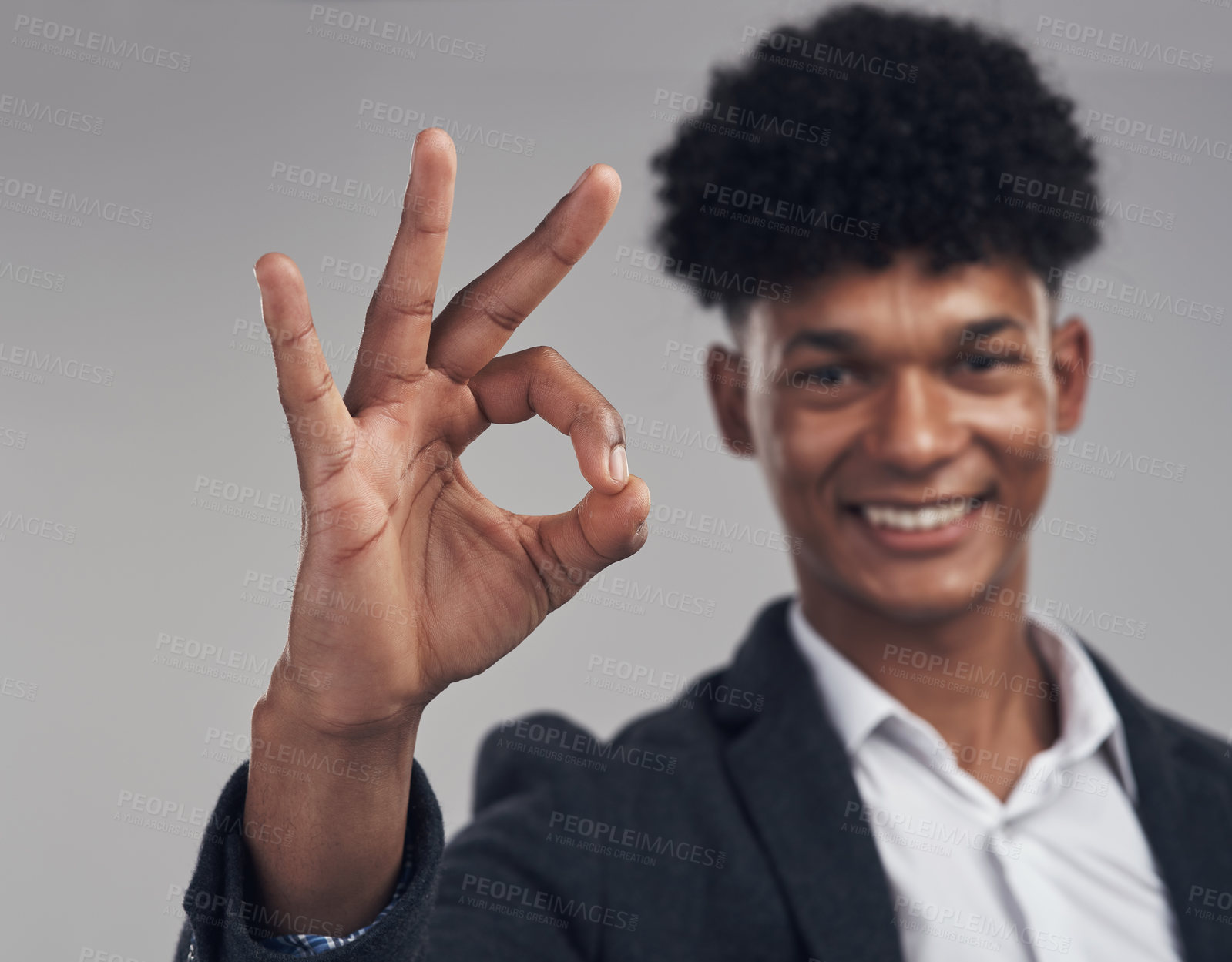Buy stock photo Studio shot of a young businessman showing an okay hand gesture against a grey background