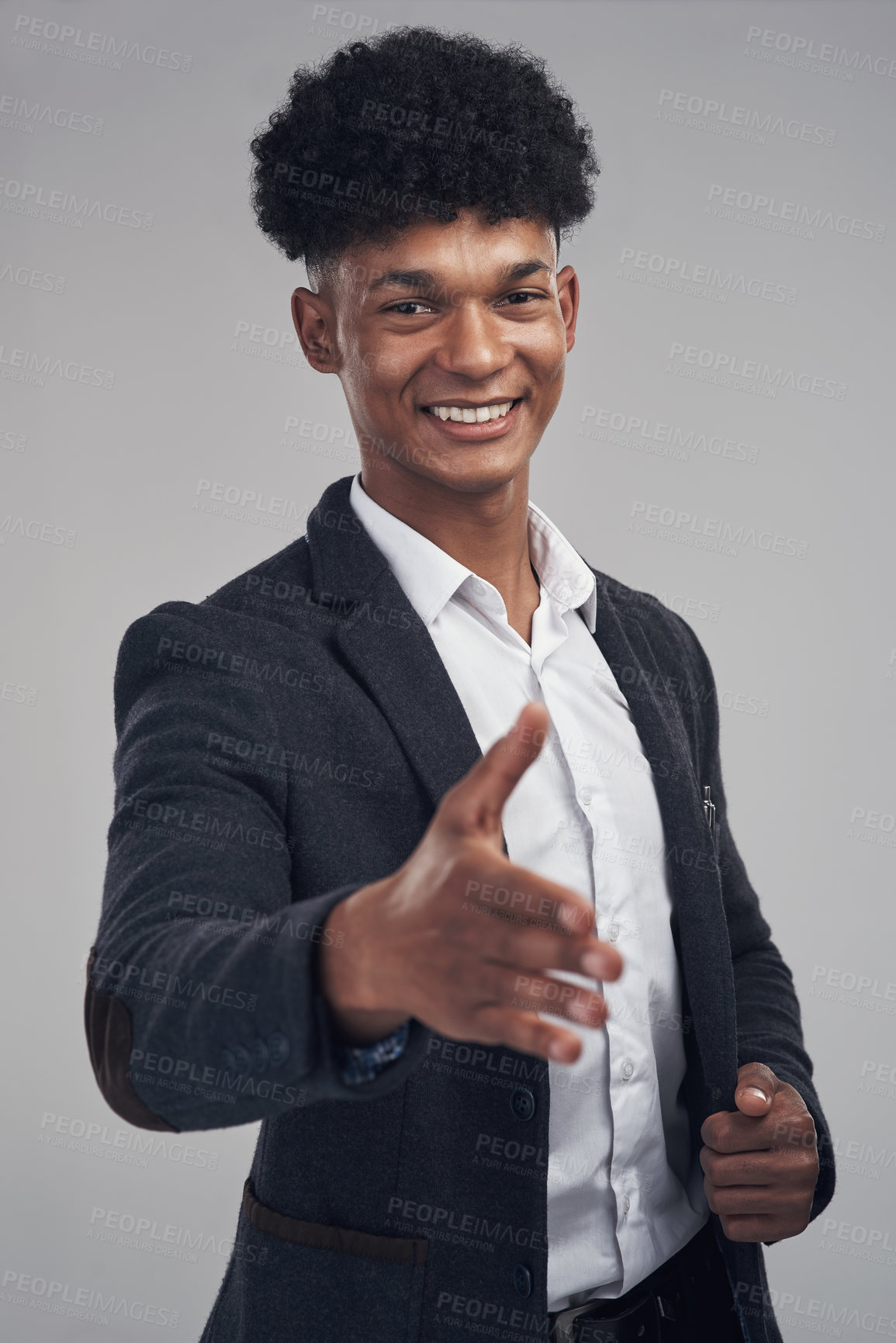 Buy stock photo Studio shot of a young businessman extending his arm for a handshake against a grey background