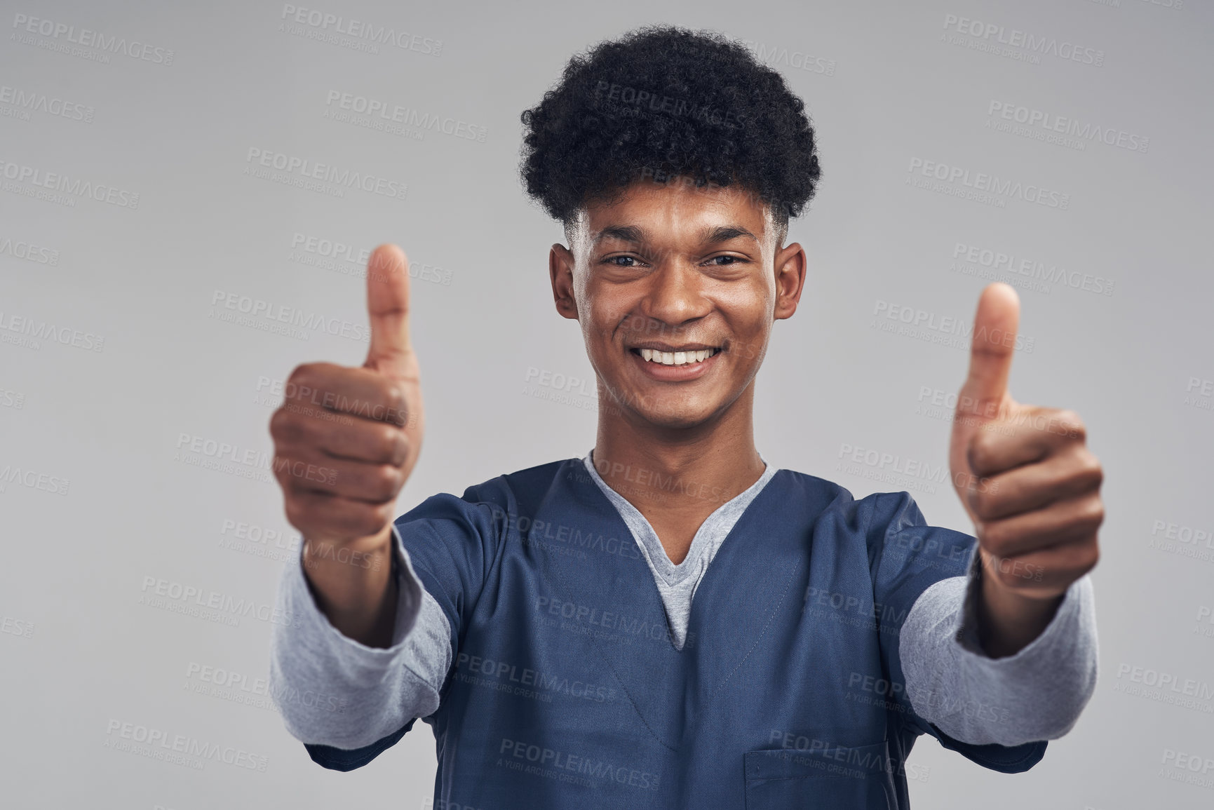 Buy stock photo Shot of a male nurse showing thumbs up while standing against a grey background