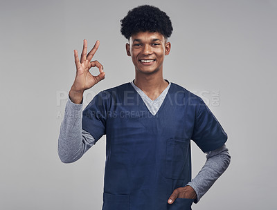 Buy stock photo Shot of a male nurse showing the ok sign while standing against a grey background