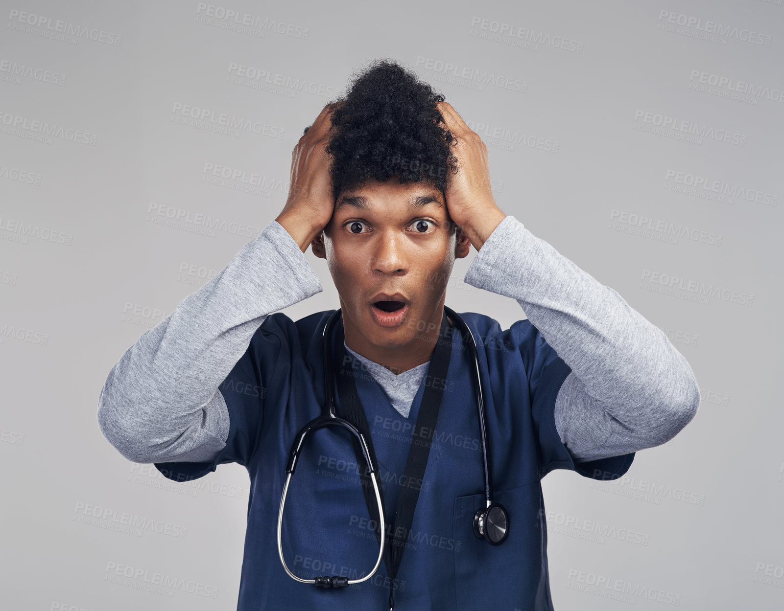 Buy stock photo Shot of a male nurse looking astonished while standing against a grey background