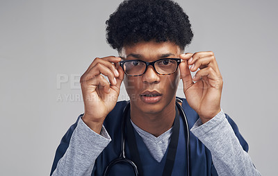 Buy stock photo Shot of a male nurse wearing glasses while standing against a grey background