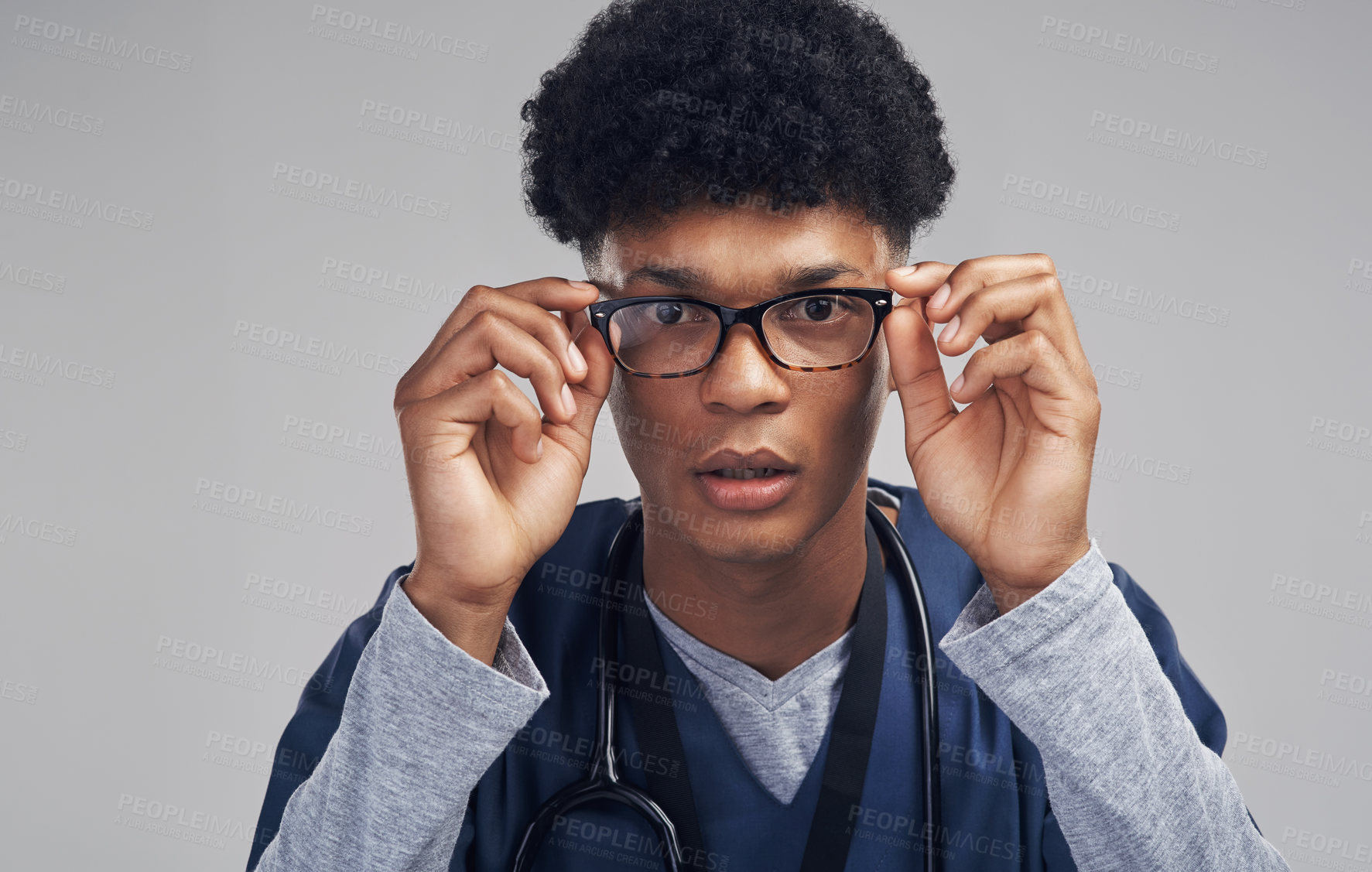 Buy stock photo Shot of a male nurse wearing glasses while standing against a grey background