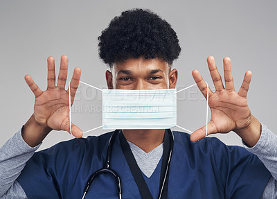 Buy stock photo Shot of a male nurse holding up a surgical mask while standing against a grey background