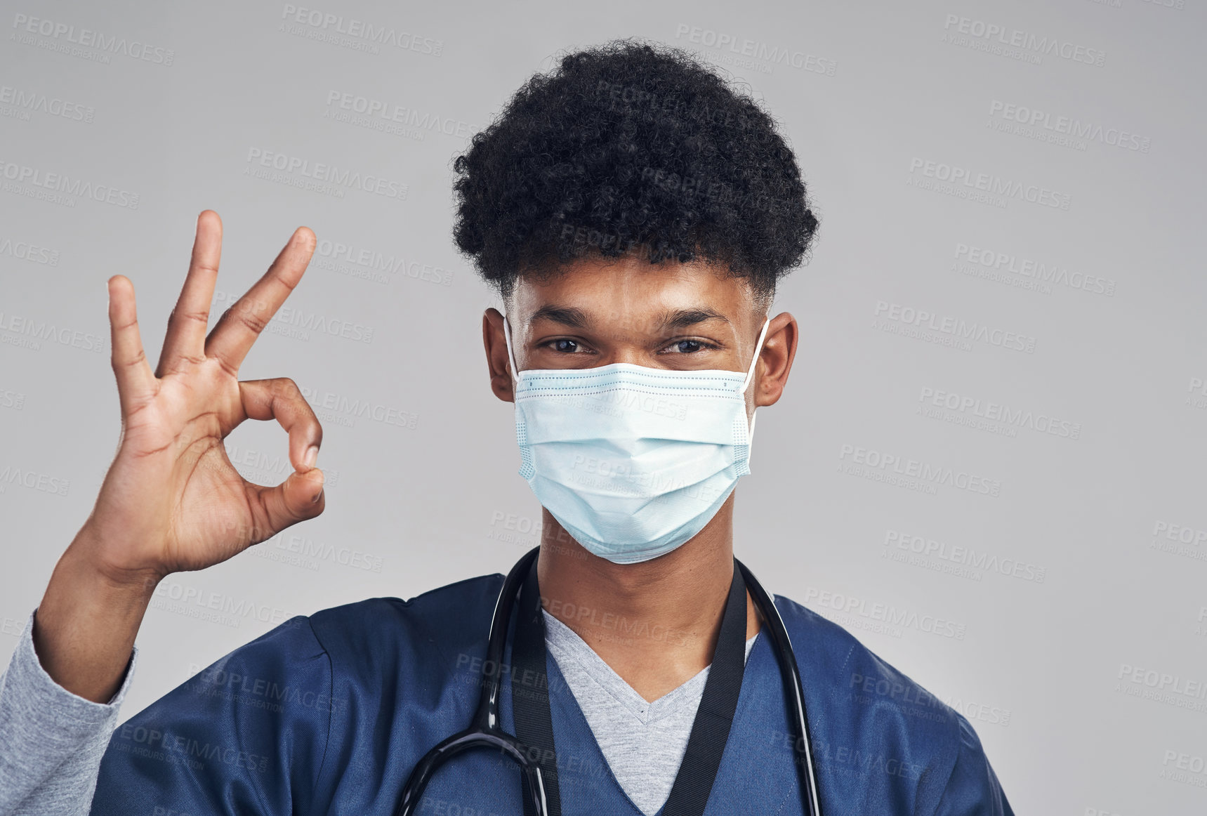 Buy stock photo Shot of a male nurse showing the ok sign while wearing a surgical mask