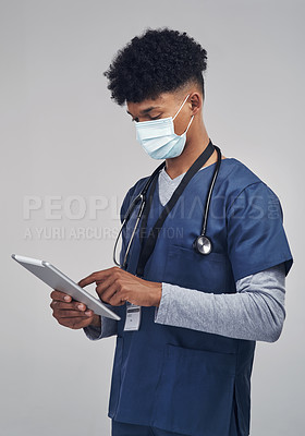 Buy stock photo Shot of a male nurse holding a digital tablet while standing against a grey background
