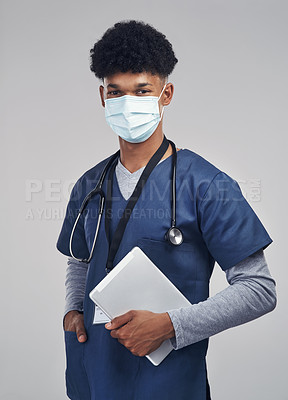 Buy stock photo Shot of a male nurse holding a digital tablet while standing against a grey background 