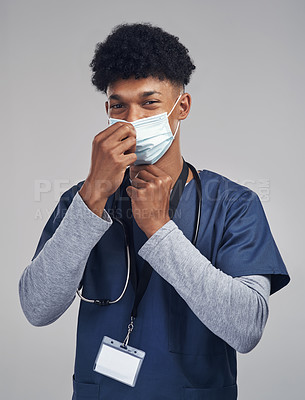 Buy stock photo Shot of a male nurse wearing a surgical mask while standing against a grey background