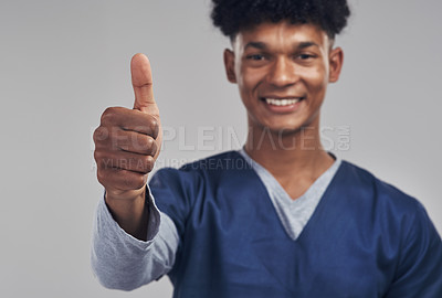 Buy stock photo Shot of a male nurse showing thumbs up while standing against a grey background