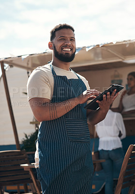 Buy stock photo Shot of a young business owner using his digital tablet