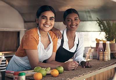 Buy stock photo Shot of two young businesswomen in their food truck