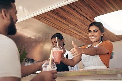 Buy stock photo Shot of a woman giving her customer his smoothies while giving him the thumbs up