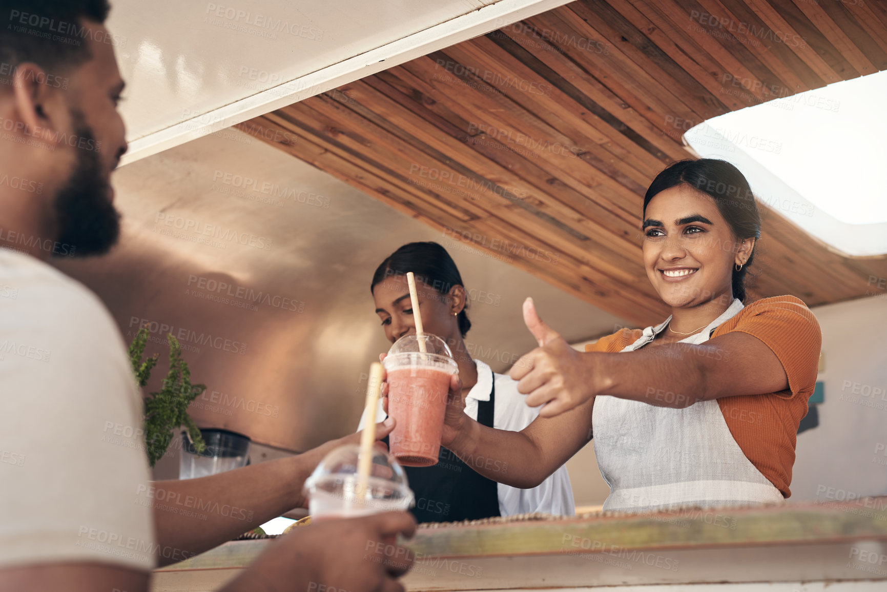 Buy stock photo Shot of a woman giving her customer his smoothies while giving him the thumbs up