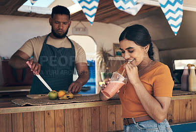 Buy stock photo Shot of a woman buying and drinking a smoothie from a food truck