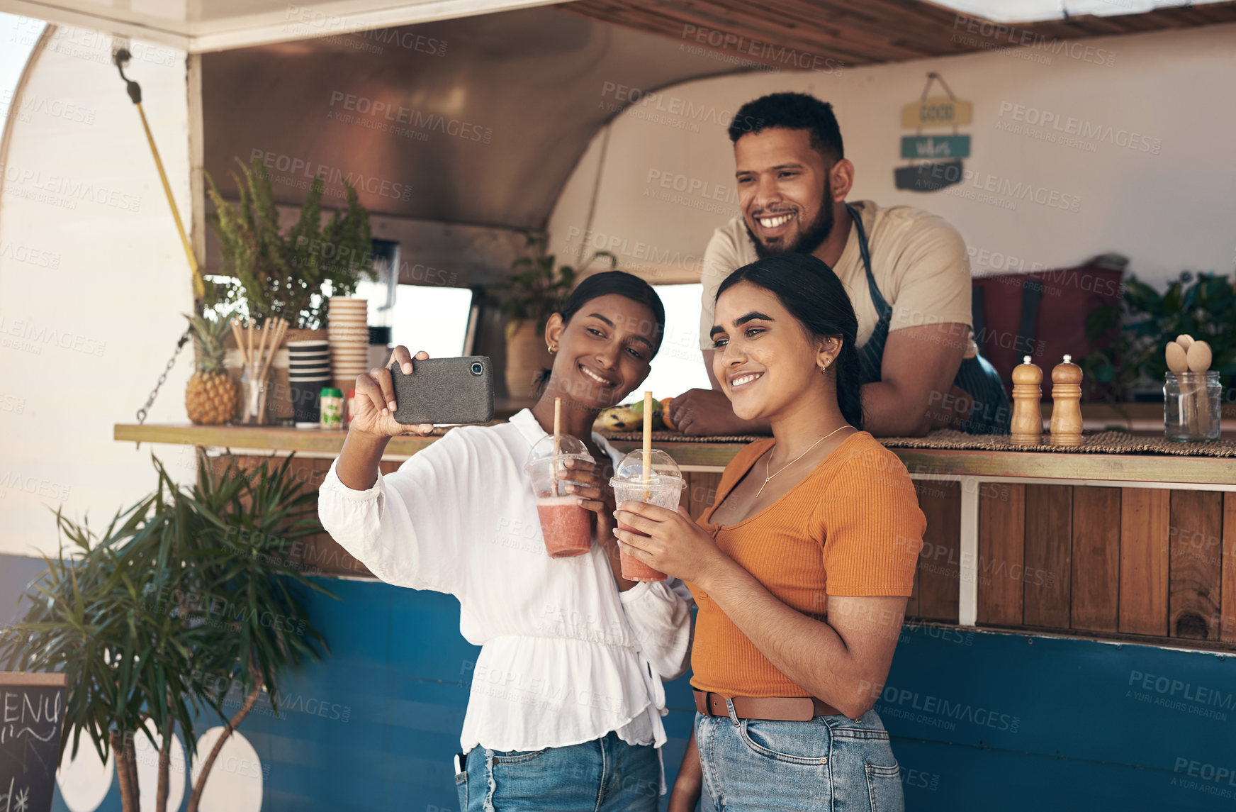 Buy stock photo Shot of two friends taking selfies while drinking smoothies