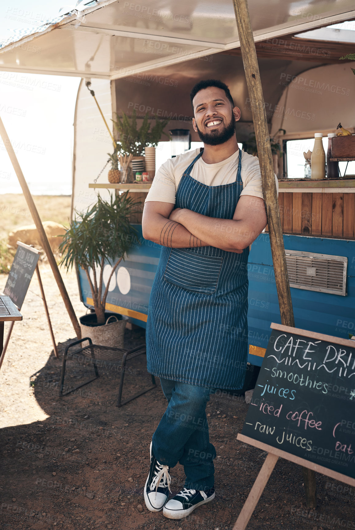 Buy stock photo Shot of a young businessman standing outside of his food truck