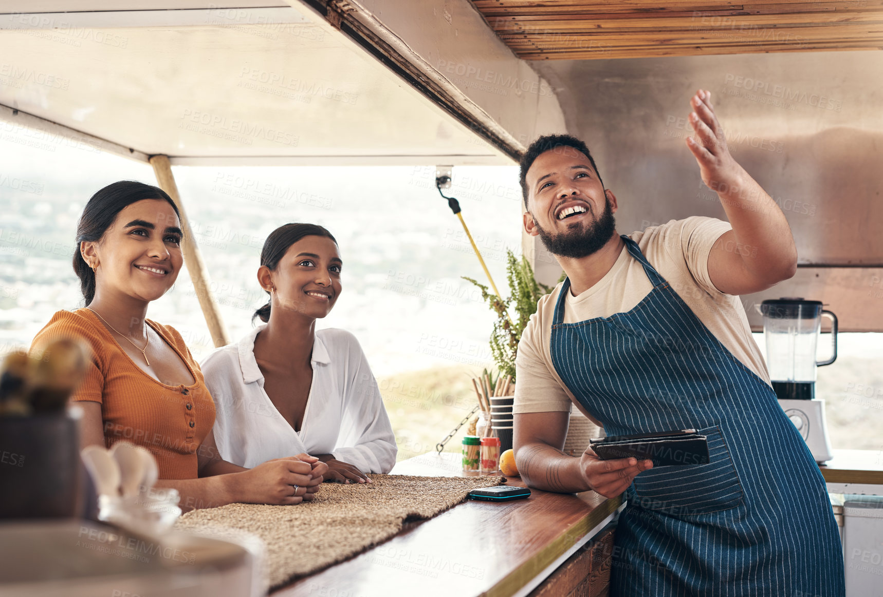 Buy stock photo Shot of two friends ordering food from a food truck