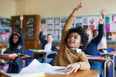 Buy stock photo Shot of a diverse group of children sitting in their school classroom and raising their hands to answer a question