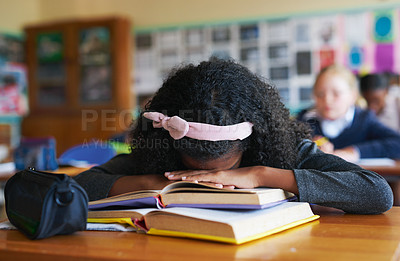 Buy stock photo Shot of an unrecognizable girl asleep on her text books in her classroom at school during the day