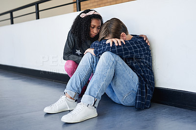 Buy stock photo Full length shot of an unrecognizable boy sitting in the school hallway and feeling depressed while a classmate comforts him