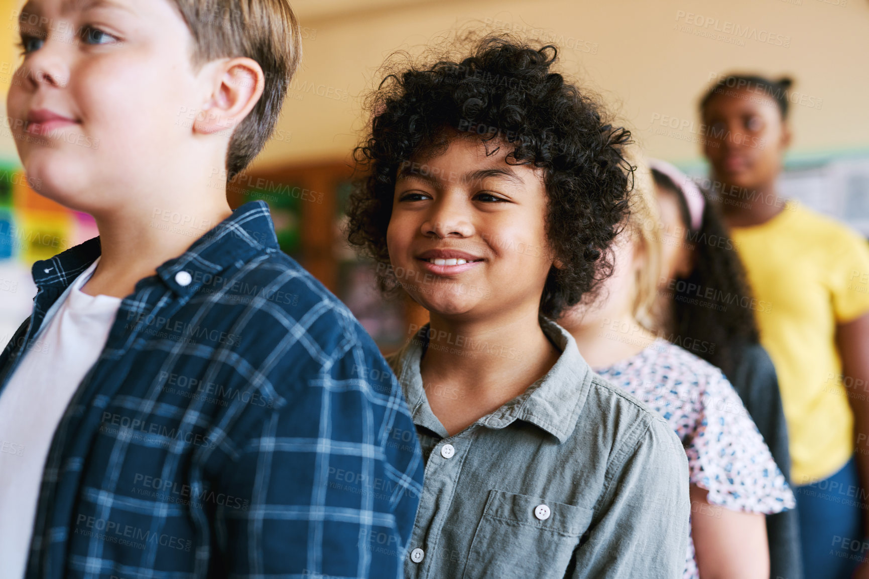 Buy stock photo Shot of a diverse group of children standing in a line in their classroom at school