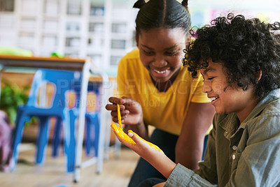 Buy stock photo Shot of two young children painting each other's hands during an art lesson at school