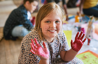 Buy stock photo Shot of a young girl sitting in her classroom at school with her hands painted
