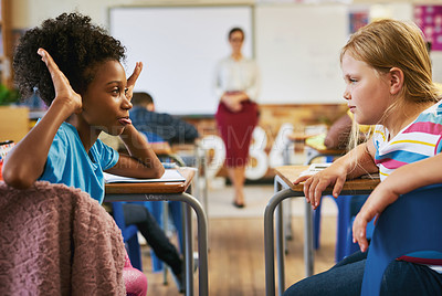 Buy stock photo Shot of a young girl sitting in the classroom at school and bullying her classmate