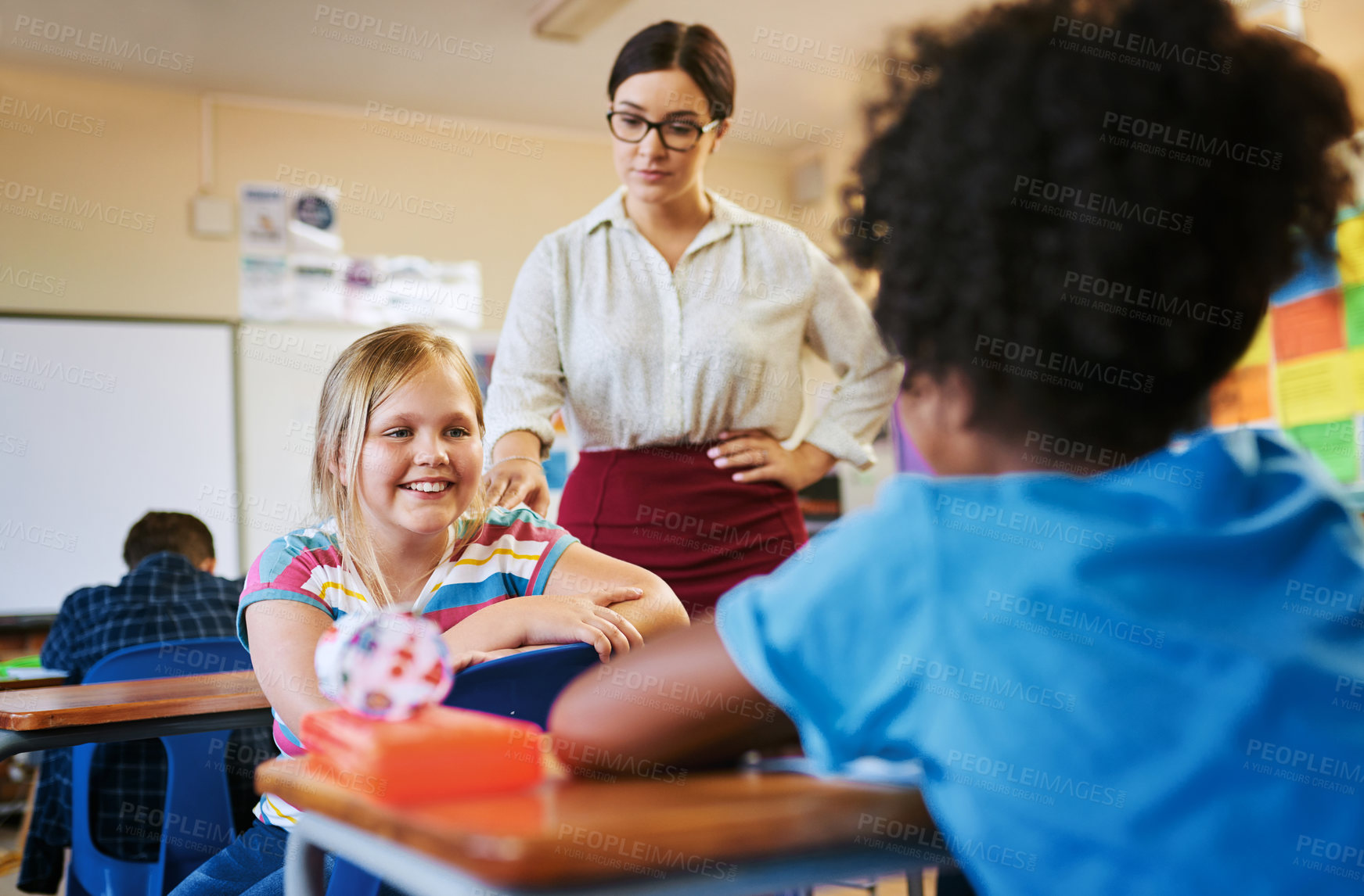 Buy stock photo Shot of a young attractive teacher disciplining the children in her classroom during a lesson